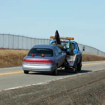 a car is being towed by a tow truck | Miami Beach | Tremont Towing | South Beach Towing