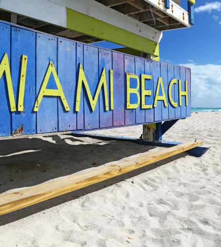 a beach with a blue and yellow sign